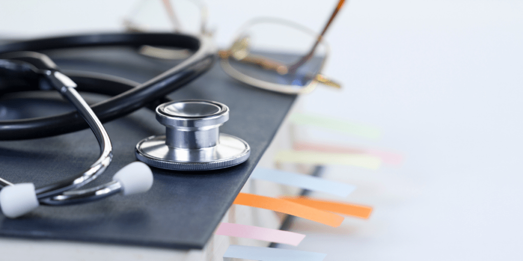 stethoscope on top of book with colourful tabs